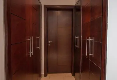 a pair of wooden doors in a hallway at Studio at Burj Views L246 in Dubai