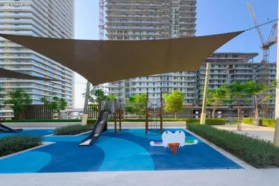 a playground in a city with tall buildings at Lush Apartment - Private Beach Emaar - Beachfront in Dubai