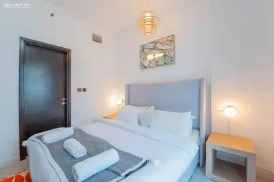 a bedroom with a large white bed and a table at Peaceful Apartment - Cozy Interiors - 1BR in JVC in Dubai