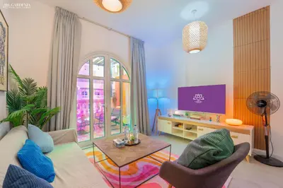 a living room with a couch and a tv at Peaceful Apartment - Cozy Interiors - 1BR in JVC in Dubai