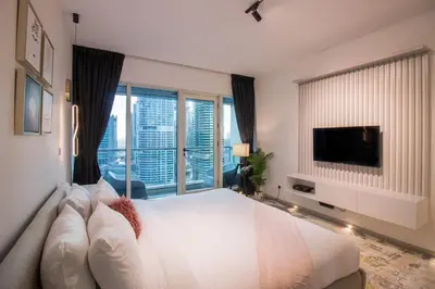 a bedroom with a large white bed and a tv at Studio at Dubai Arch 2005 in Dubai