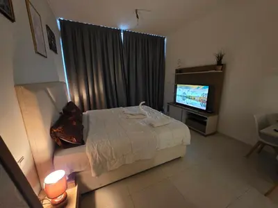 a bedroom with a bed and a flat screen tv at Dragon Golden Apartment 003 in Dubai