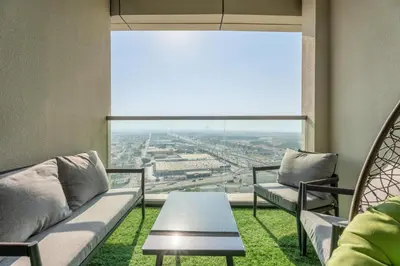 a living room with a couch and a table and a large window at GuestReady - 2BR l City Chic in the Sky in Dubai