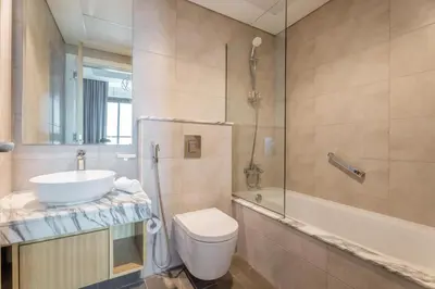 a bathroom with a toilet and a sink and a shower at GuestReady - 2BR l City Chic in the Sky in Dubai