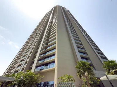 a tall building with palm trees in front of it at GuestReady - 2BR l City Chic in the Sky in Dubai
