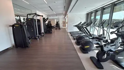 a gym with a row of treadmills and machines at Downtown with Direct Access Dubai Mall & Burj Khalifa in Dubai