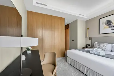 a bedroom with a bed and a table and a chair at Address Residences Dubai Opera - Boulevard Views 1 & 2 Bedroom Apartment 5 minute walk to Burj Khalifa & Dubai Mall by NAMUVE in Dubai