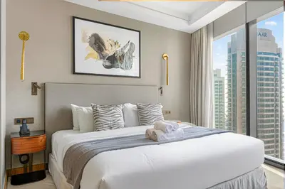 a bedroom with a large white bed with a large window at Address Residences Dubai Opera - Boulevard Views 1 & 2 Bedroom Apartment 5 minute walk to Burj Khalifa & Dubai Mall by NAMUVE in Dubai