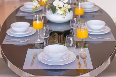 a round table with plates and glasses of orange juice at 2BR - DAMAC Towers by Paramount - Business Bay in Dubai