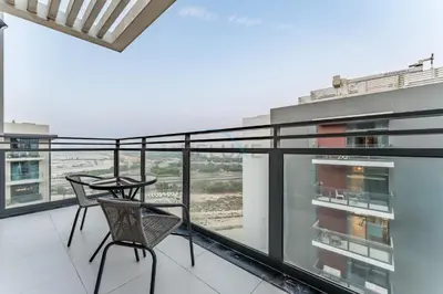 a balcony with a table and chairs on a building at Furnished Balcony with Creek Views, Near Ras Al Khor Wildlife Sanctuary and Downtown Dubai - Wilton Park Residences 1, Sobha Hartland by Deluxe Holiday Homes in Dubai