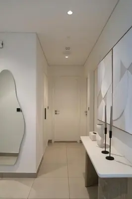 a bathroom with white walls and a large mirror at Designed 2BR in Socio Dubai Hills in Dubai
