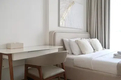 a bedroom with a desk and a bed with white pillows at Designed 2BR in Socio Dubai Hills in Dubai