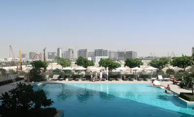 a large swimming pool with a city in the background at Designed 2BR in Socio Dubai Hills in Dubai
