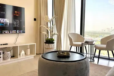 a living room with a table and a large window at Spacious apartment with Burj Khalifa view close to Dubai mall! in Dubai