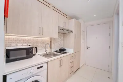 a small kitchen with a sink and a microwave at Seven Palm Residence with Beach access in Dubai