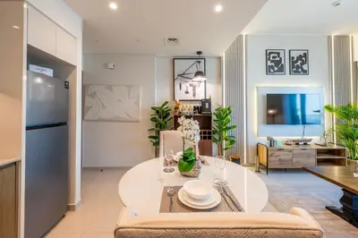 a kitchen and living room with a table and a couch at Stunning 1 Bedroom Panoramic Views at Burj Royale in Dubai