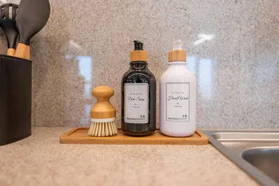 two bottles of soap and a brush on a cutting board at Stunning 1 Bedroom Panoramic Views at Burj Royale in Dubai
