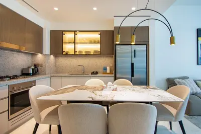 a kitchen with a table and chairs in a kitchen at Skyline Serenity - Luxury Beachfront Living in Dubai