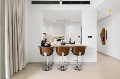 a kitchen with two bar stools and a counter at BLVD Luxury 2BHK with Private Pool Near Circle Mall in Dubai