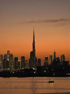 a city skyline at sunset with a boat in the water at Address Point Tower 2 in Dubai