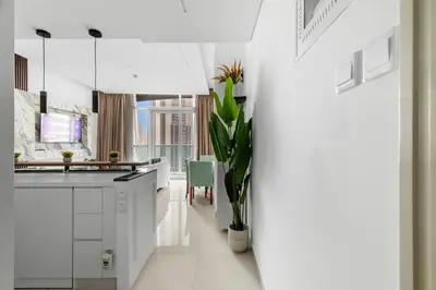 a white kitchen with a plant in a vase at Modern 2BR Luxury Apartment with Downtown Dubai & Burj Khalifa Views in Dubai