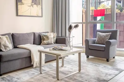 a living room with a couch and a chair and a table at Frank Porter - Torch Tower Marina in Dubai