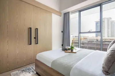 a bedroom with a large bed and a large window at Frank Porter - Golf Gate 1 in Dubai