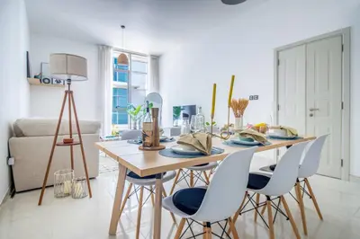 a dining room table and chairs in a living room at Frank Porter - Polo Residence C5 in Dubai