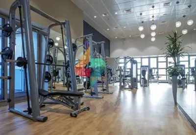 a gym with several tread machines in a room at Marina Princess Tower Dubai Apartment in Dubai