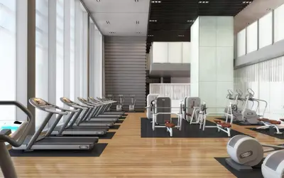 a gym with a row of treadmills and machines at Blueground DIFC pool gym DXB-505 in Dubai
