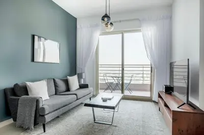 a living room with a couch and a large window at Blueground Icon Tower city view gym parking DXB-1332 in Dubai