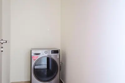 a washing machine in the corner of a room at Blueground JLT pool gym nr Marina JBR DXB-1616 in Dubai