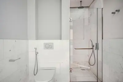 a white bathroom with a shower and a toilet at Blueground The Palm Jumeirah pool nr Atlantis DXB-1712 in Dubai