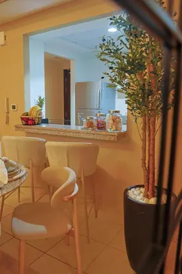 a kitchen with a counter with chairs and a plant at Rare apt with views of both Marina and JBR wheel in Dubai