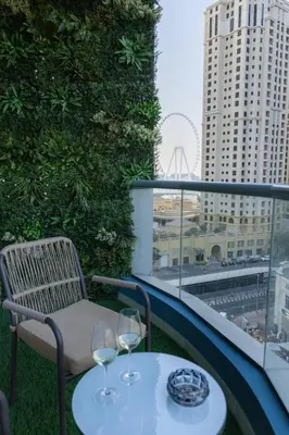 a balcony with a table and two wine glasses at Rare apt with views of both Marina and JBR wheel in Dubai