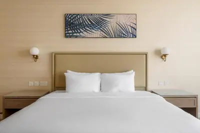 a large bed in a hotel room with two lamps at Blueground The Palm Jumeirah pool nr Atlantis DXB-1717 in Dubai
