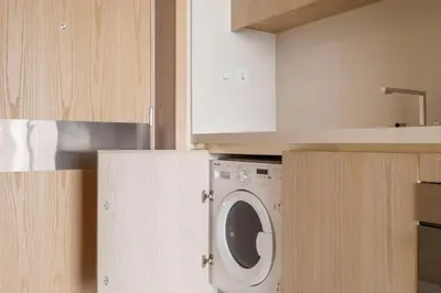 a kitchen with a white washer and dryer at Blueground The Palm Jumeirah pool nr Atlantis DXB-1719 in Dubai
