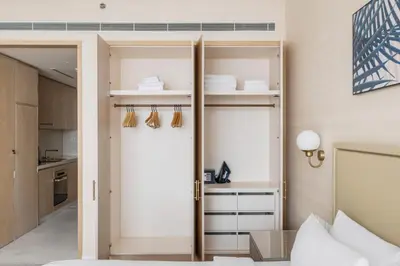 a room with a bed and a closet with shelves at Blueground The Palm Jumeirah jacuzzi nr Atlantis DXB-1720 in Dubai