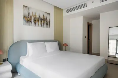a bedroom with a white bed and a painting on the wall at Blueground Downtown Dubai pool nr Burj Khalifa DXB-1735 in Dubai