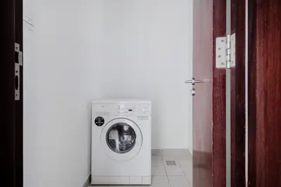 a washer and dryer in a room next to a door at Blueground JLT pool nr Lake DXB-1747 in Dubai