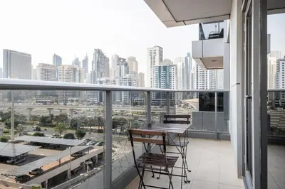 a balcony with chairs and a view of a city at Blueground JLT pool nr Lake DXB-1747 in Dubai