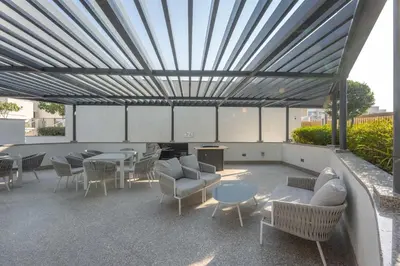 a patio with tables and chairs and awning at StayShort - Modern 1 Bed in Meydan Sleeps 4 in Dubai