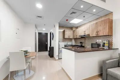 a kitchen and living room with a counter and a table at StayShort - Chic Studio Apartment in JVC Sleeps 4 in Dubai