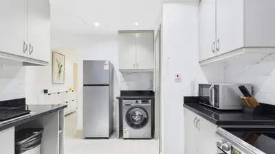 a kitchen with a washing machine and a refrigerator at Spacious 2 BR with Sea and Marina View Bahar JBR in Dubai