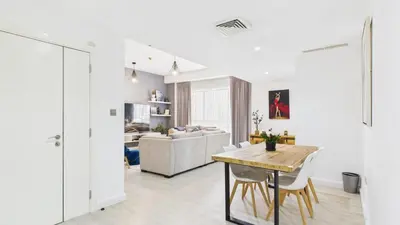 a living room with a table and a couch at Spacious 2 BR with Sea and Marina View Bahar JBR in Dubai