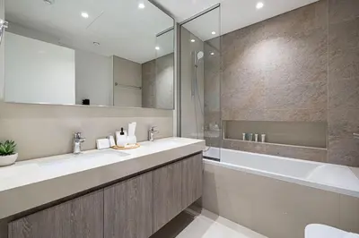 a bathroom with two sinks and a tub and a mirror at Modern 2BR Apartments near Dubai Mall, Downtown in Dubai
