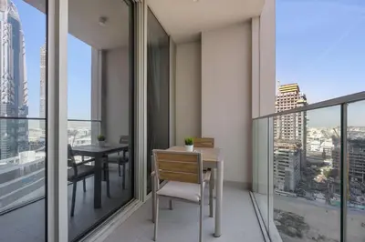 an apartment balcony with a table and chairs at 2BR - Private Cinema - Pool - Walk to Burj Khalifa in Dubai
