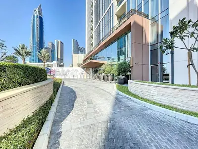 a cobblestone street in a city with tall buildings at 2BR - Private Cinema - Pool - Walk to Burj Khalifa in Dubai