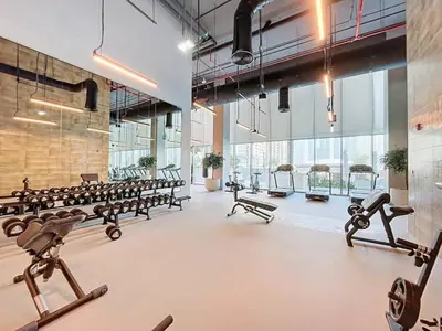 a gym with rows of exercise equipment and large windows at 2BR - Private Cinema - Pool - Walk to Burj Khalifa in Dubai