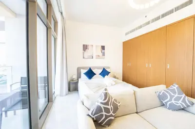 a bedroom with a large bed and a couch at EasyGo - Chic Studio Escape in Dubai Sports City in Dubai